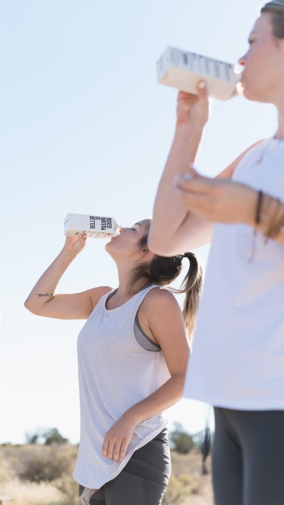 Zwei Frauen trainieren und trinken Boxed Water